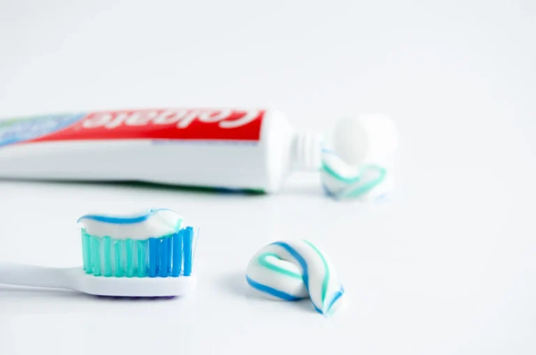 there is a toothbrush and toothpaste on a white surface