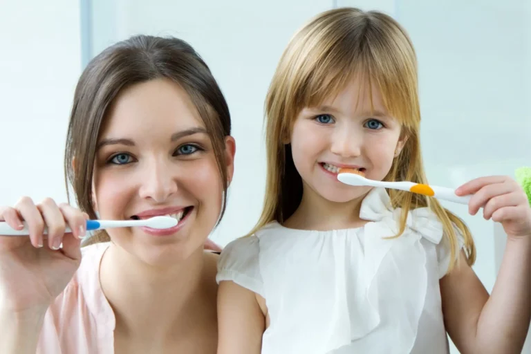 there are two women that are brushing their teeth together