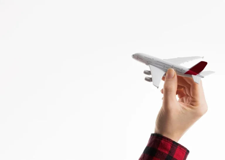 someone holding a model airplane in their hand against a white background