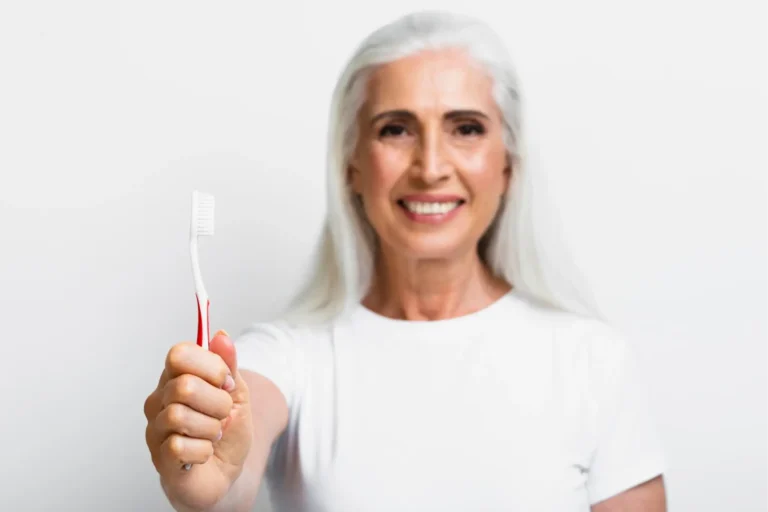 smiling woman holding a toothbrush in her hand and a toothbrush in her hand