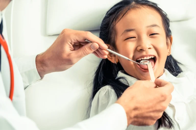 arafed child getting her teeth brushed by a doctor