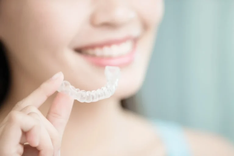 a close up of a woman holding a clear plastic retainer