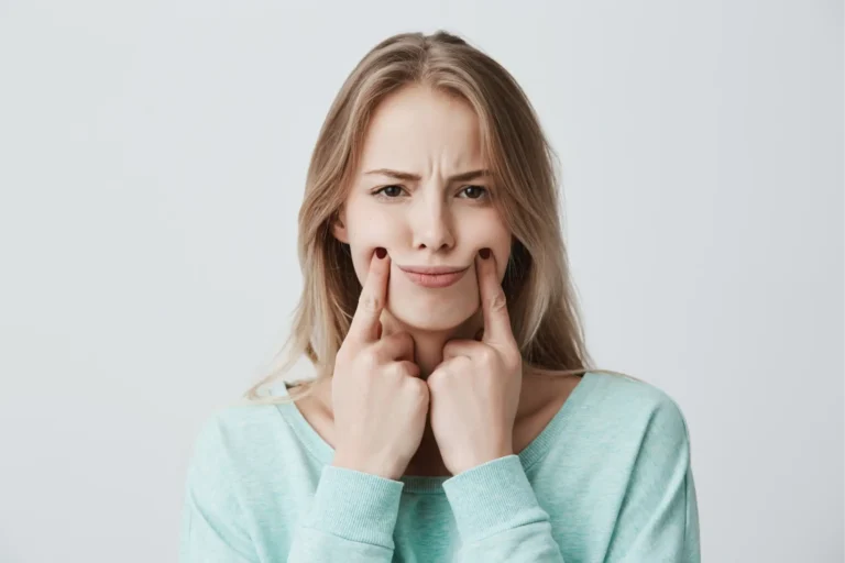 a woman with a toothache holding her chin in front of her face