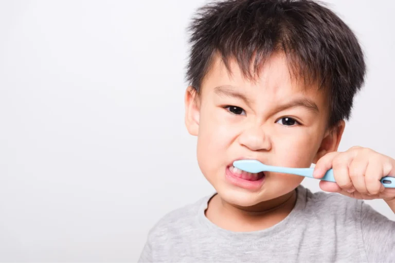 there is a young boy brushing his teeth with a toothbrush