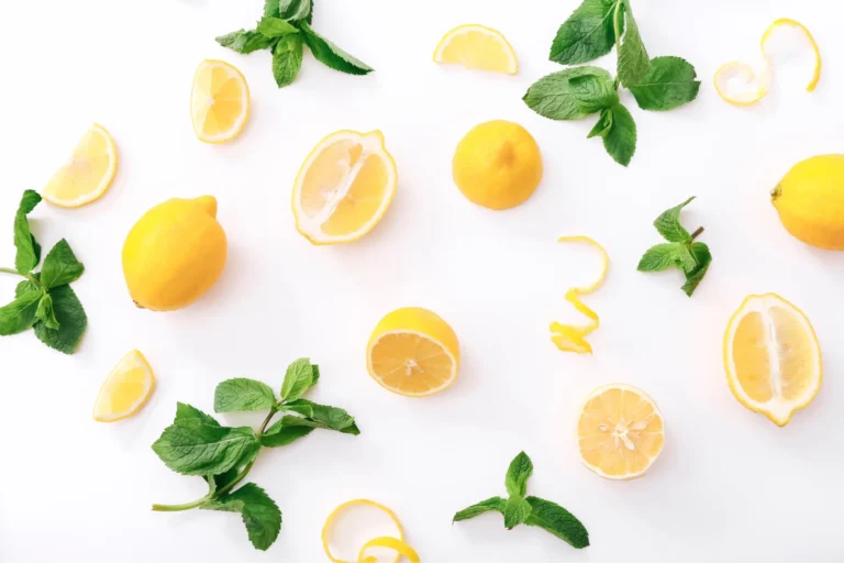 there are many lemons and mint leaves on a white surface