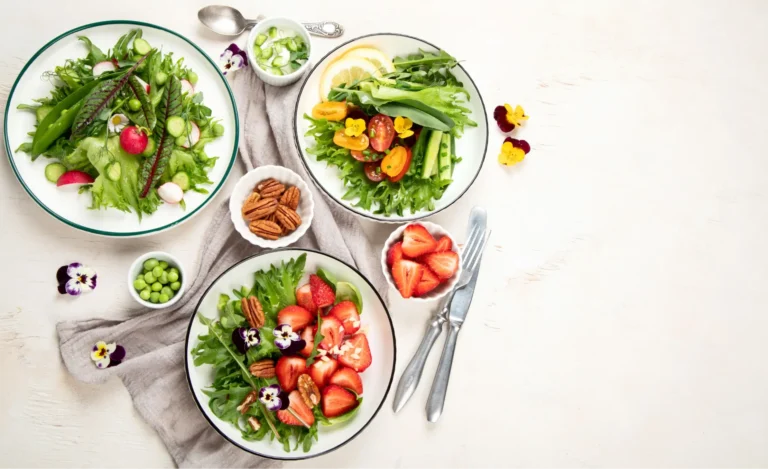 there are four plates of food on a table with forks and spoons