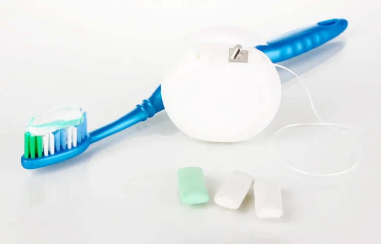 there is a toothbrush and toothpaste on a white surface