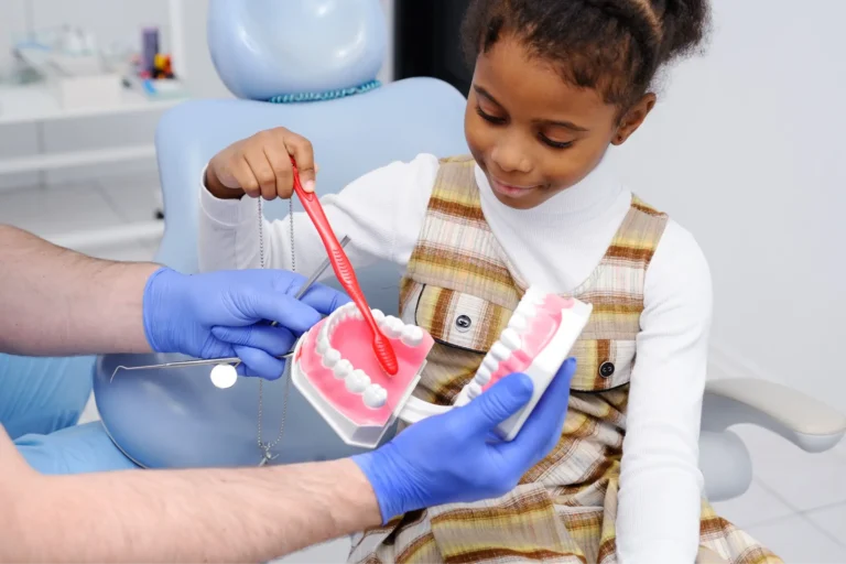 there is a little girl getting her teeth brushed by a dentist