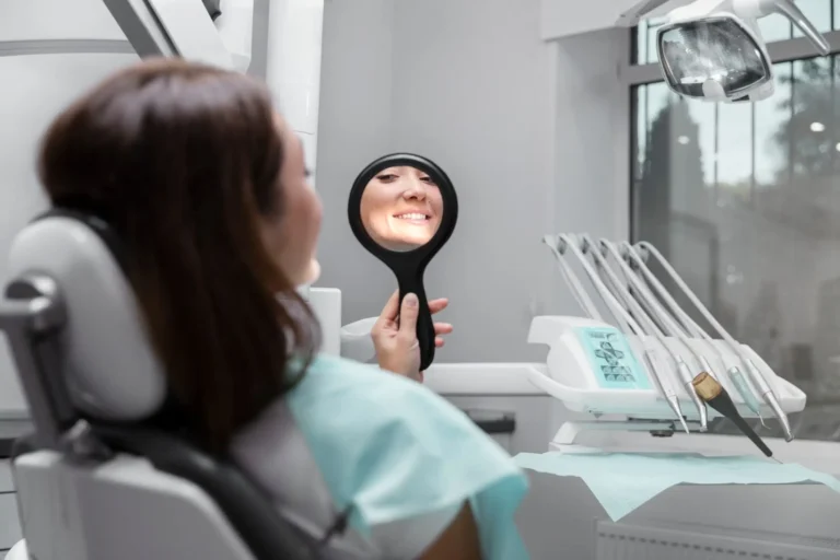 woman looking at mirror in dental office with mirror in front of her