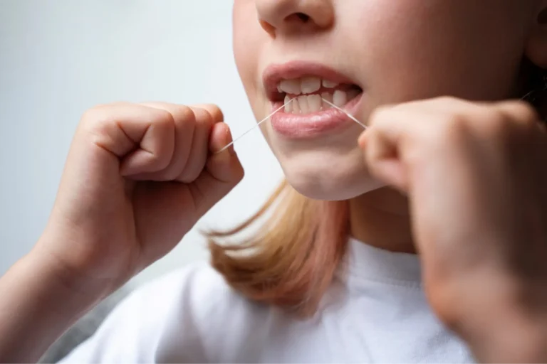 there is a young girl brushing her teeth with a toothbrush