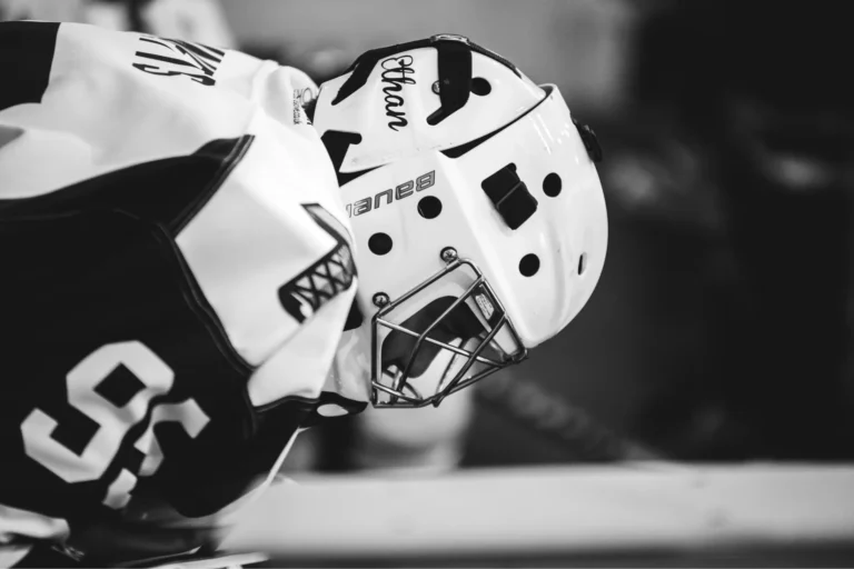 a close up of a hockey player wearing a helmet and a jersey