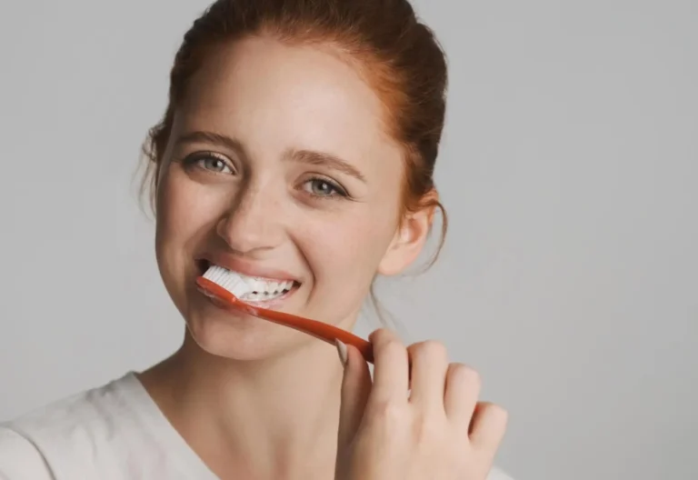 there is a woman brushing her teeth with a toothbrush