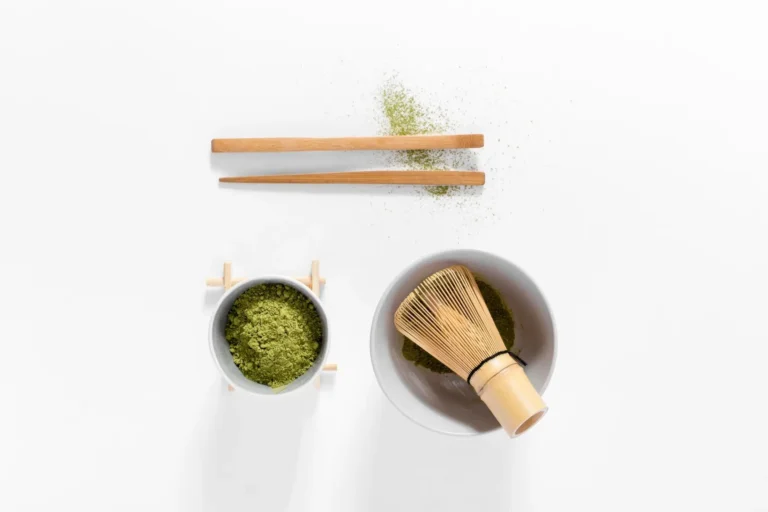 there is a bowl of matcha and a whisk in a bowl