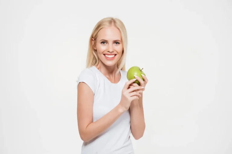 arafed woman holding an apple and smiling at the camera