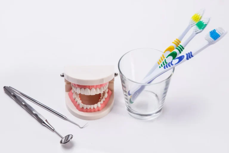 there are two toothbrushes and a toothbrush holder next to a glass