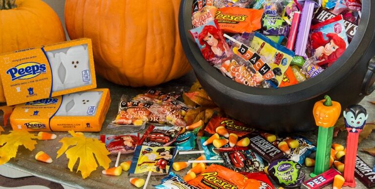 a close up of a halloween candy bucket with candy and candies