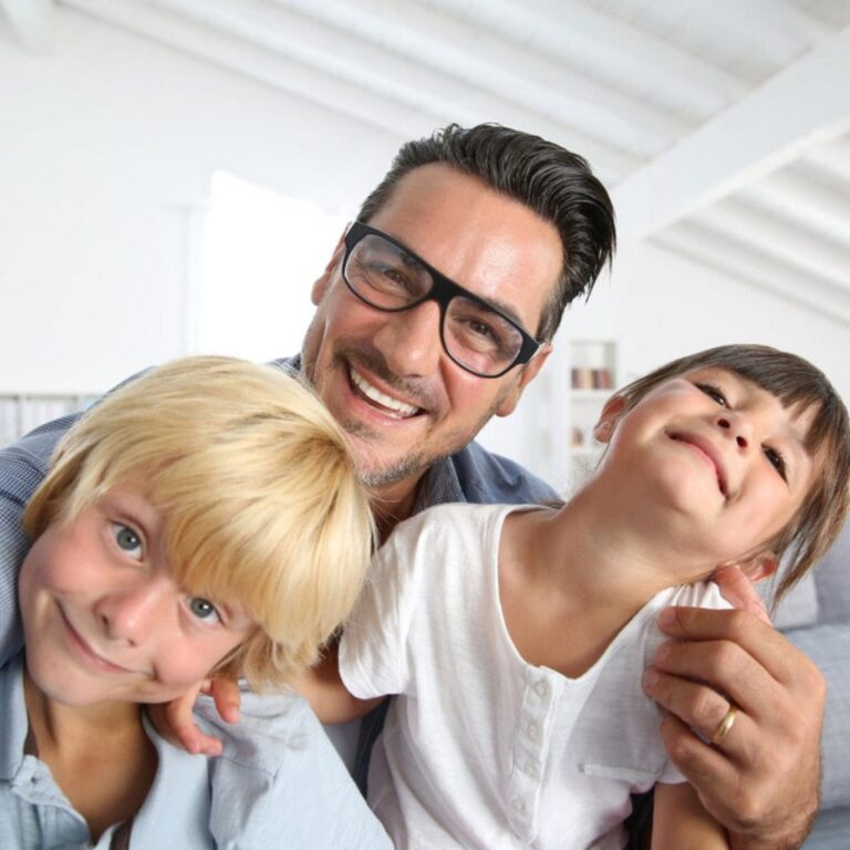 there are two boys and a man sitting on a couch