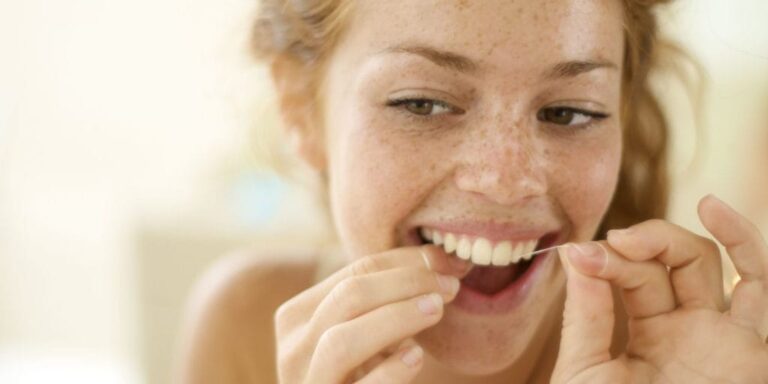 there is a woman brushing her teeth with a toothbrush