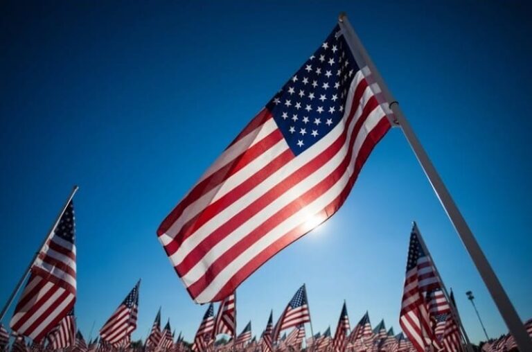 flags are flying in the wind at a memorial