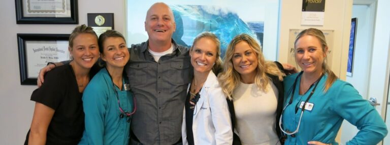 smiling doctors pose for a picture in a hospital room