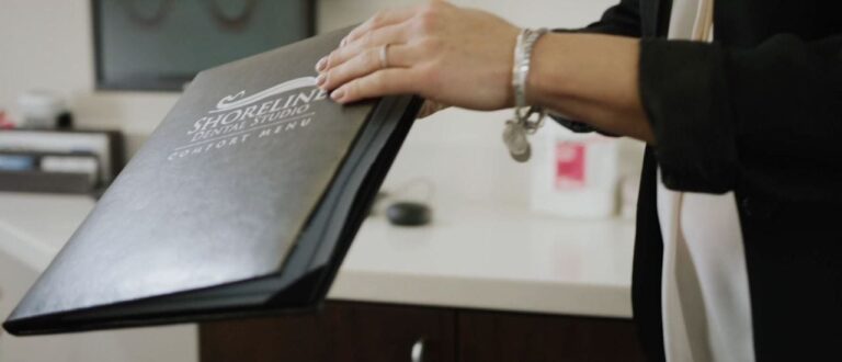 someone holding a black folder with a logo on it