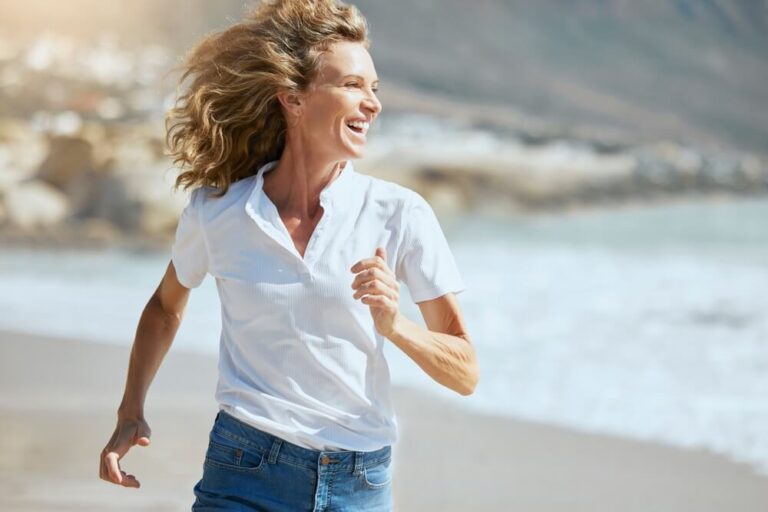 woman running on the beach with her hair blowing in the wind