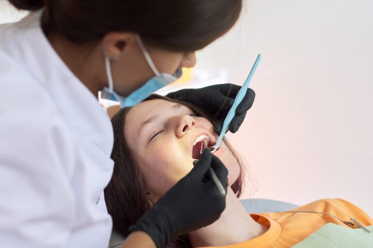 arafed woman getting her teeth examined by a dentist