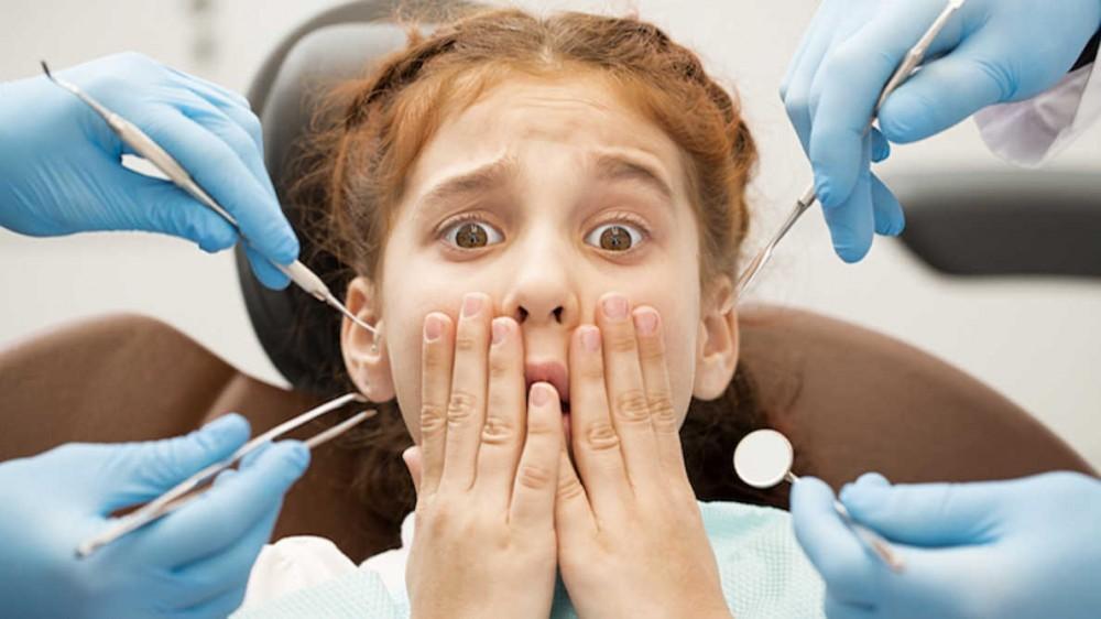 arafed child getting her teeth examined by a dentist