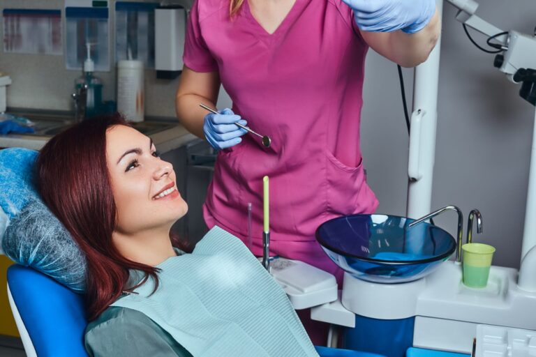 woman in a dental chair with a dentist holding a toothbrush