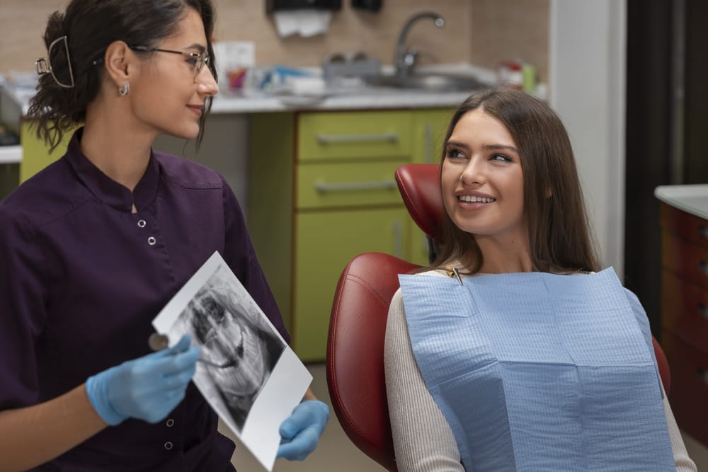 woman in a dentist chair with a patient in a chair