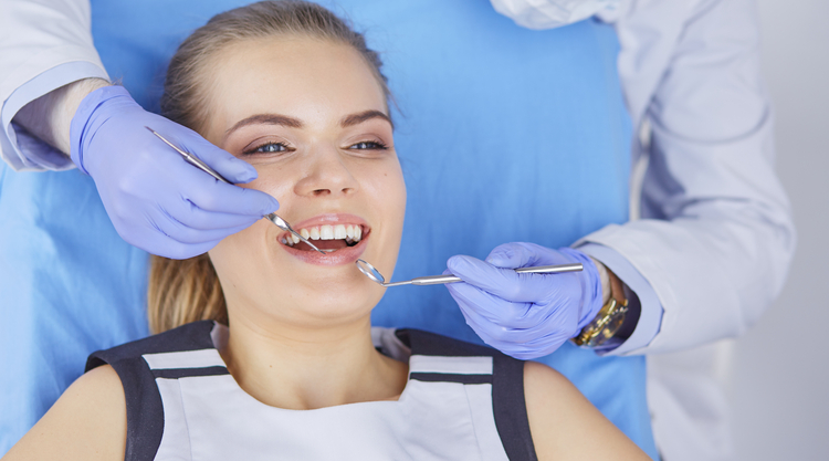 arafed woman getting her teeth examined by a dentist