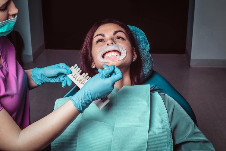 arafed woman getting her teeth brushed by a dentist