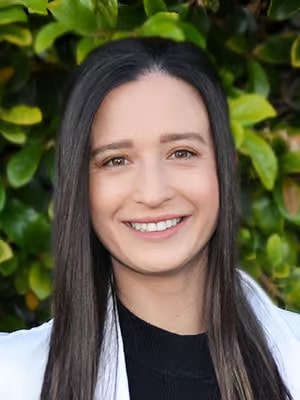 a close up of a woman with long hair and a white jacket