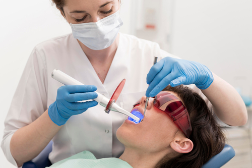 woman getting her teeth brushed by a dentist in a dental office