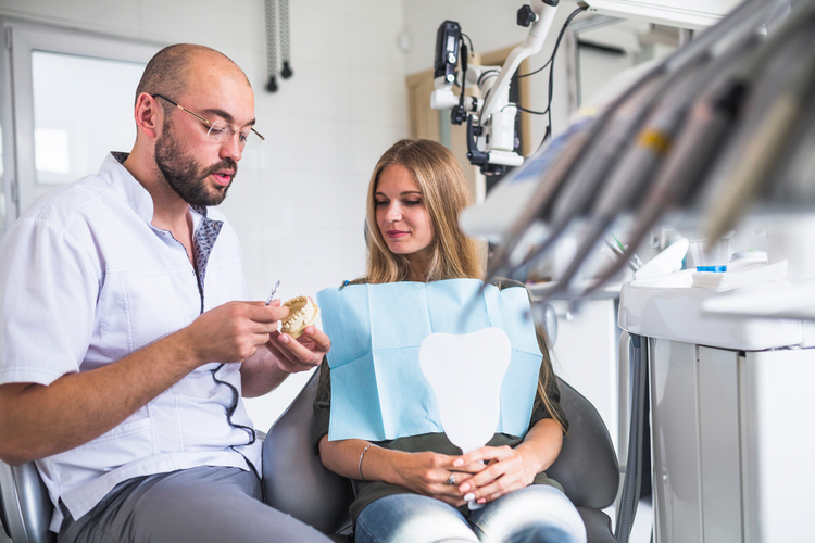 arafed man and woman sitting in a dental chair looking at a folder