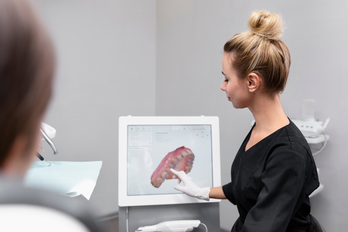 woman in black shirt looking at a computer screen with a human brain on it