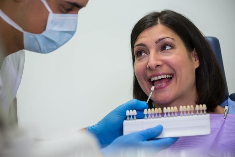 woman with a toothbrush in her mouth and a man in a mask