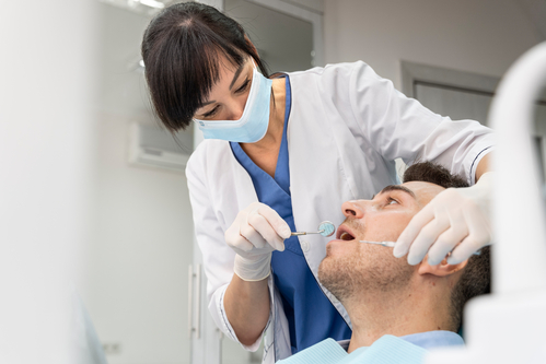 arafed male patient in a dental office getting his teeth brushed