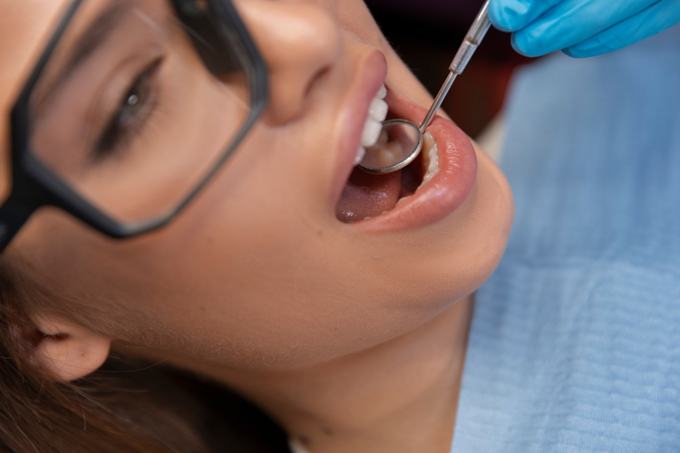 arafed woman getting her teeth brushed by a dentist