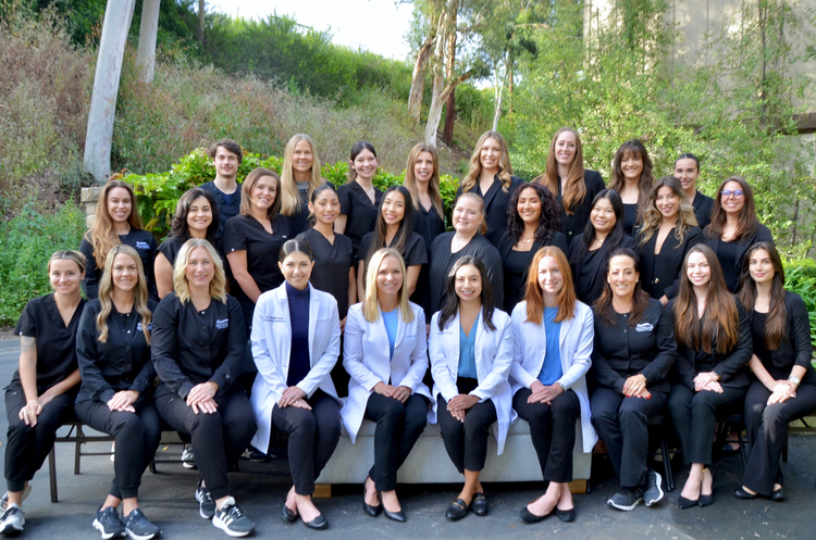 arafed group of women in black and white lab coats posing for a picture