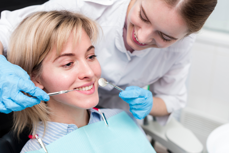 woman getting her teeth brushed by a dentist in a dental office