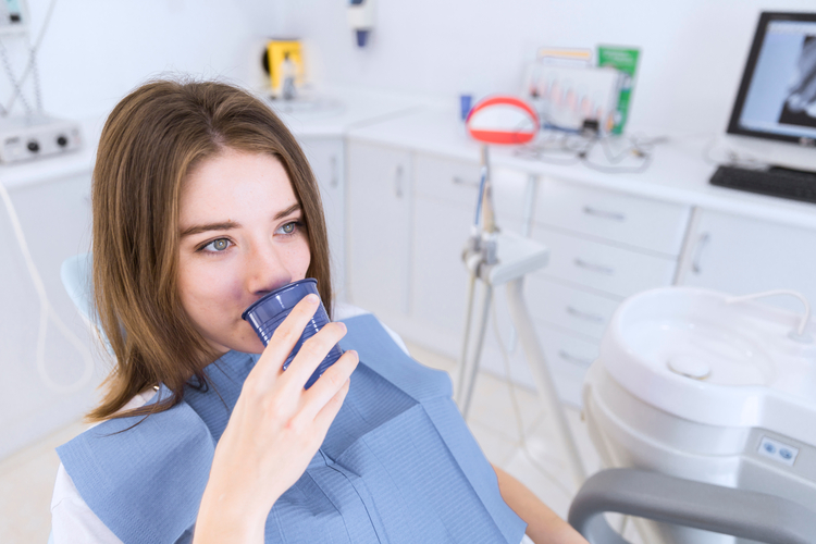 woman sitting in a chair with a toothbrush in her mouth