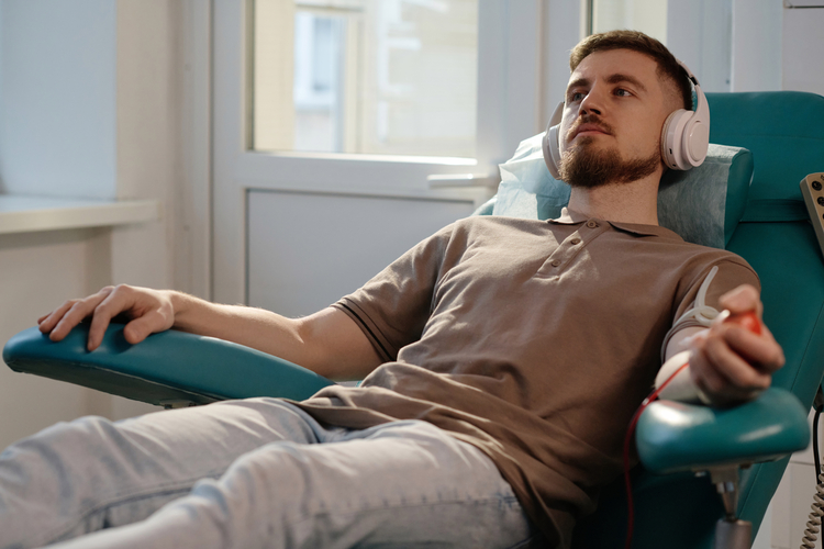 arafed man in a chair with headphones on and a remote control