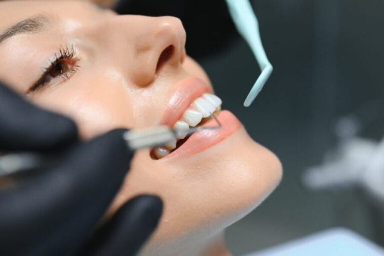 arafed woman getting her teeth brushed by a dentist