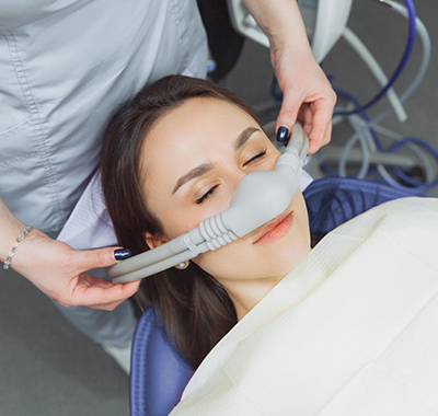 woman getting a nose mask with a machine in a room