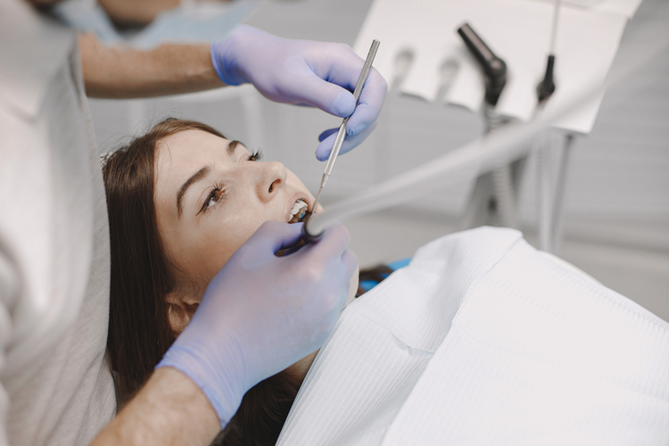 arafed woman getting her teeth examined by a dentist