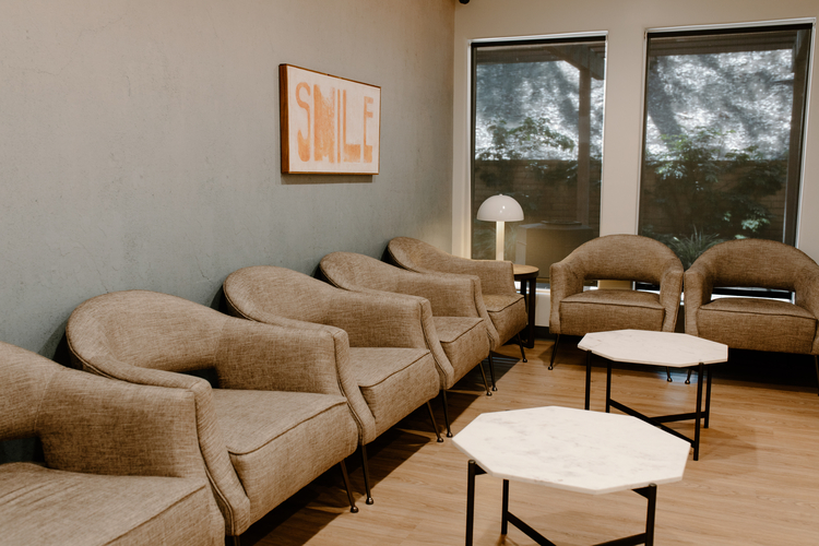 there are many chairs and tables in a waiting room