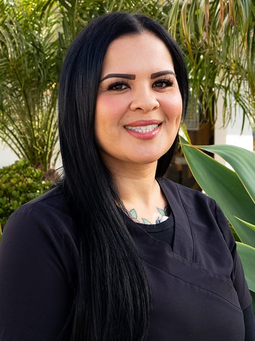 smiling woman with long black hair and a black top