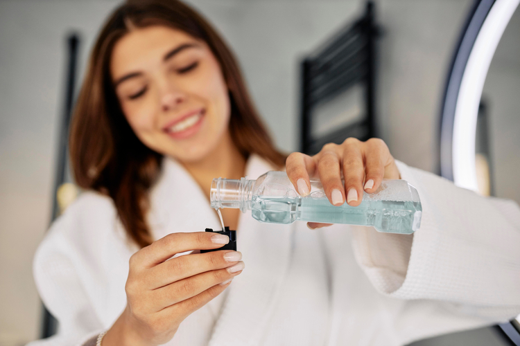 arafed woman in a bathrobe holding a bottle of water and a toothbrush