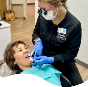 arafed woman getting her teeth examined by a dentist